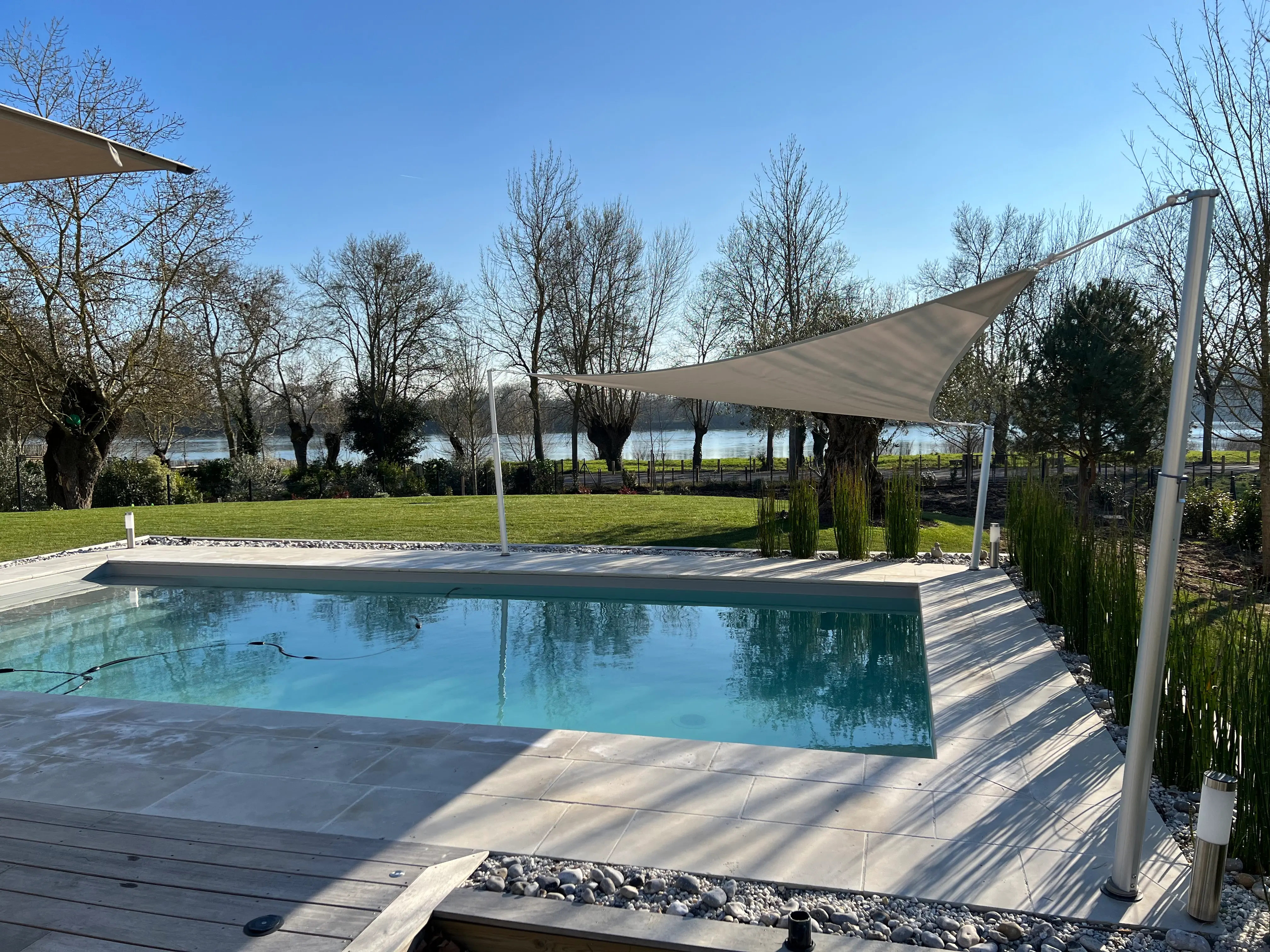 Voile triangulaire au-dessus d'une piscine avec mâts télescopiques