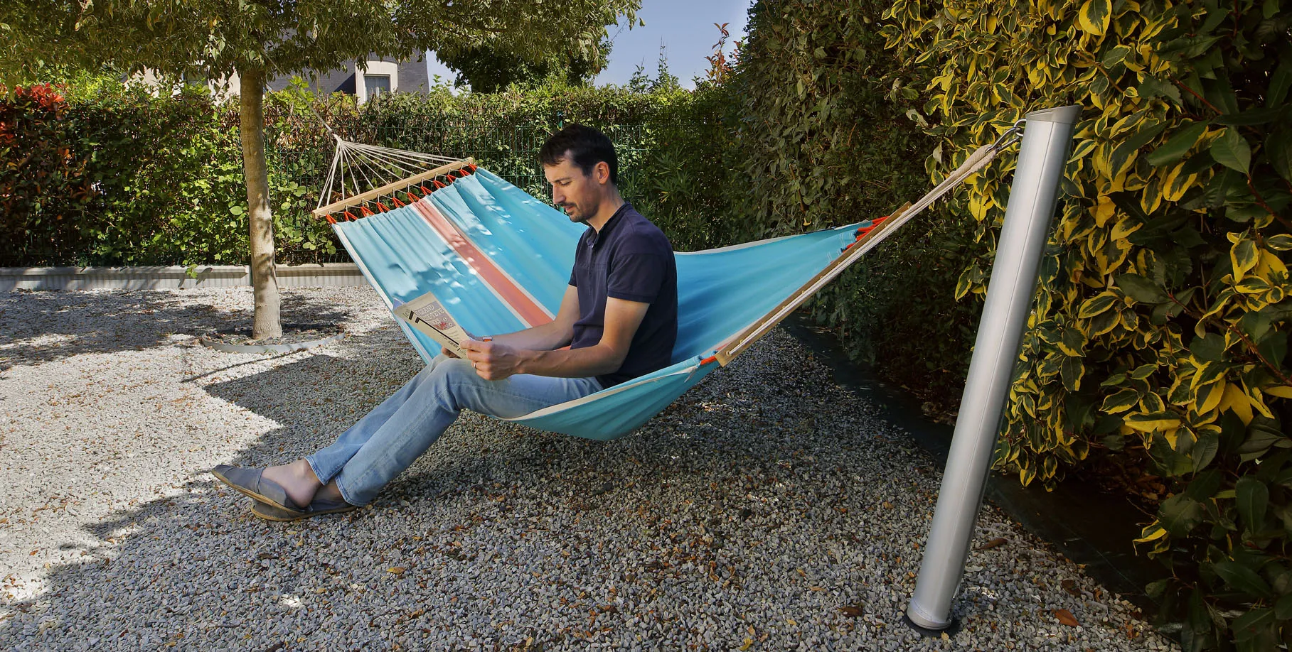 hamac suspendu entre un arbre et un poteau Gard&Rock discret, sans pied encombrant, pour une installation légère et élégante