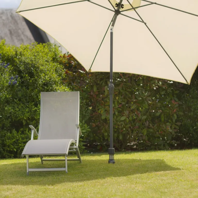 chaise longue sous un parasol incliné sans pied lourd et encombrant, solution discrète et épurée pour se relaxer au jardin
