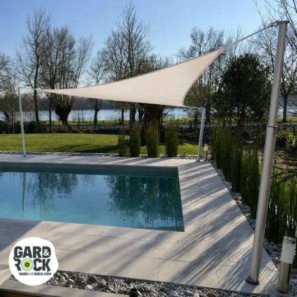 Taud d’ombrage tendue au-dessus d’une piscine, offrant protection solaire et ambiance élégante.